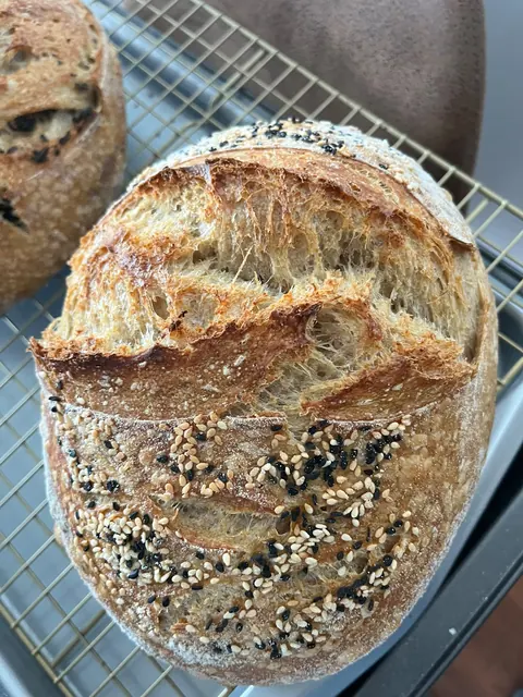 Une miche aux graines avec une belle grigne, la croûte soulevée le long de l’incision.